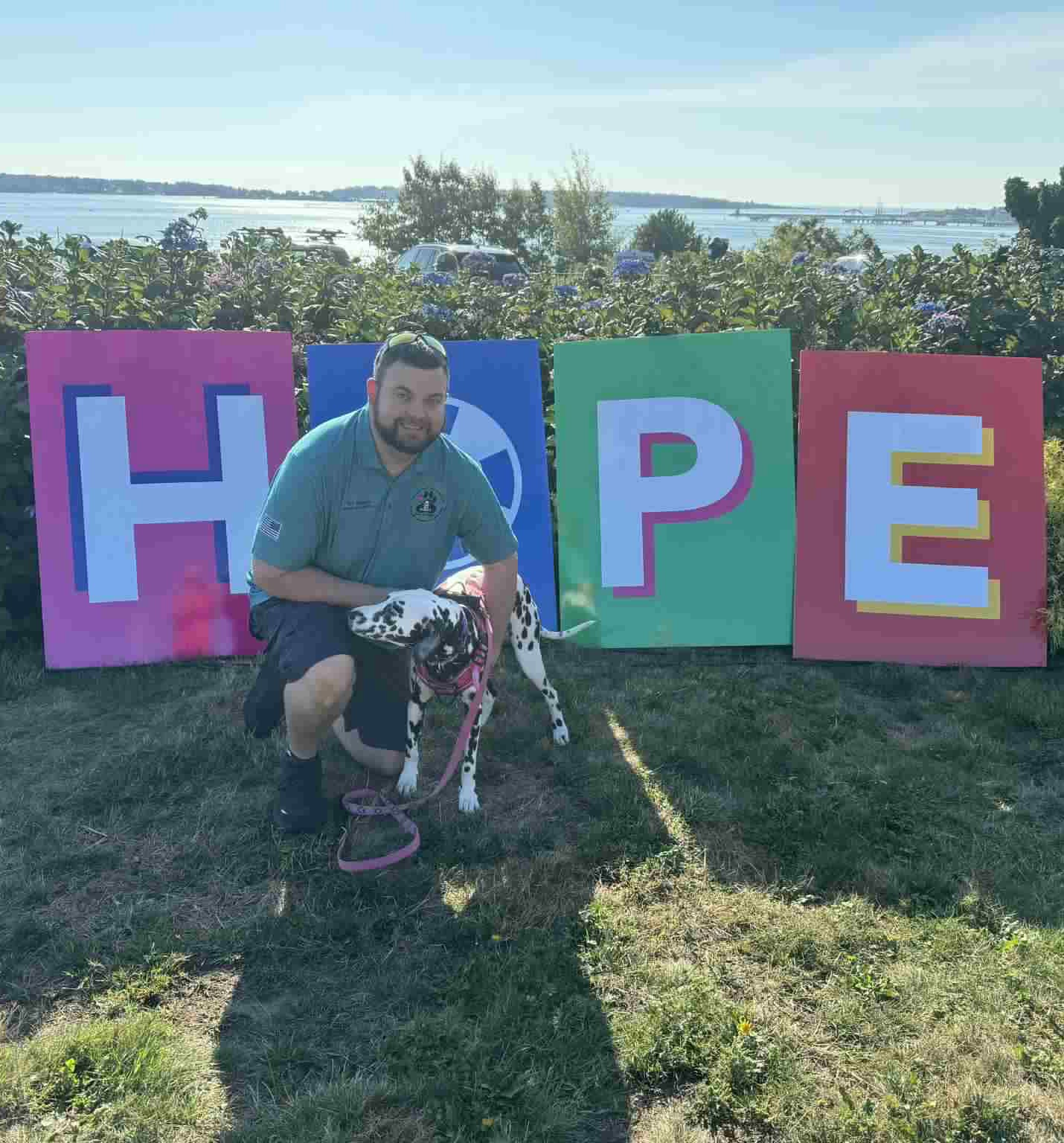Hope sign behind a man with one of his service dogs for PTSD